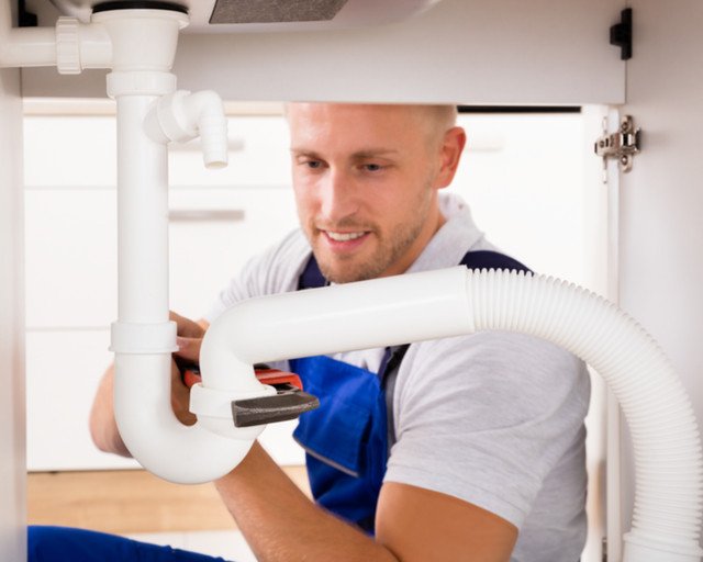 Plumber unblocking sink image by Andrey Popov (via Shutterstock).